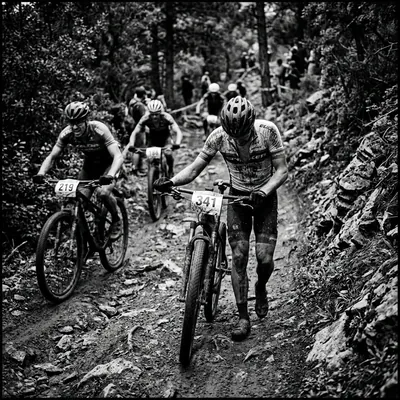 Ciclista empurrando bike na trilha